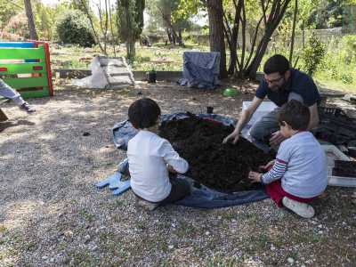 In un angolo Angelo ha preso con s� due bambini: la sua "lezione" consiste nell'insegnare a mischiare humus e terreno, ottenendo un composto che verr� travasato in vasetti assieme a dei semini da piantare